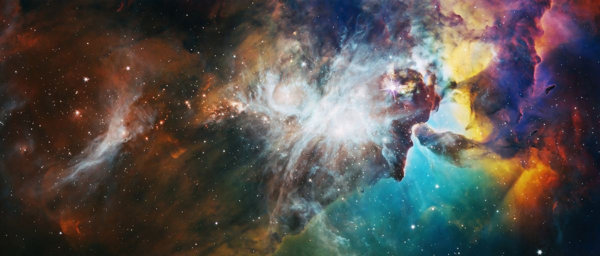 A wide, highly saturated nebula: rust and orange cloud on the left, a white and pale-blue core around a single bright starburst in the centre, and teal, yellow and magenta banks on the right, with dark dust pillars standing against them and stars scattered throughout.